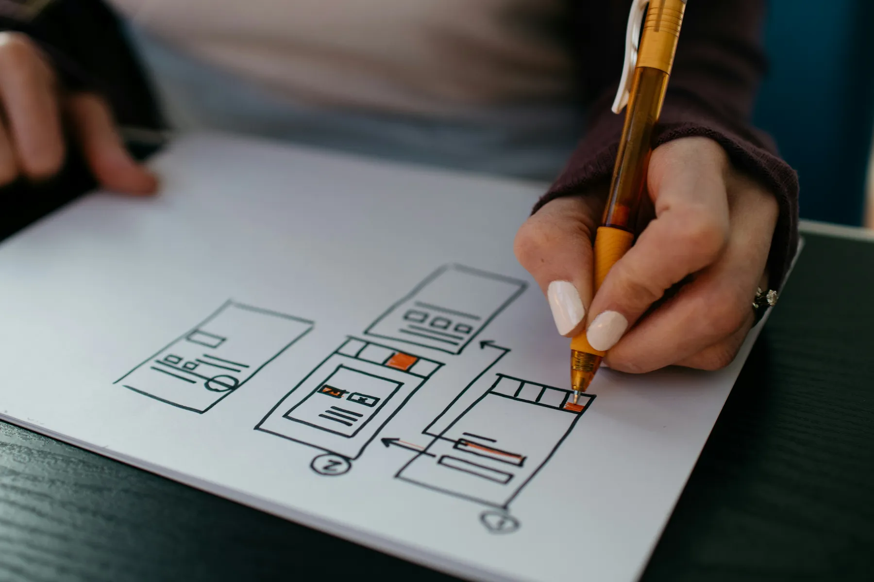 Designer sketching wireframes for a user interface in a notebook