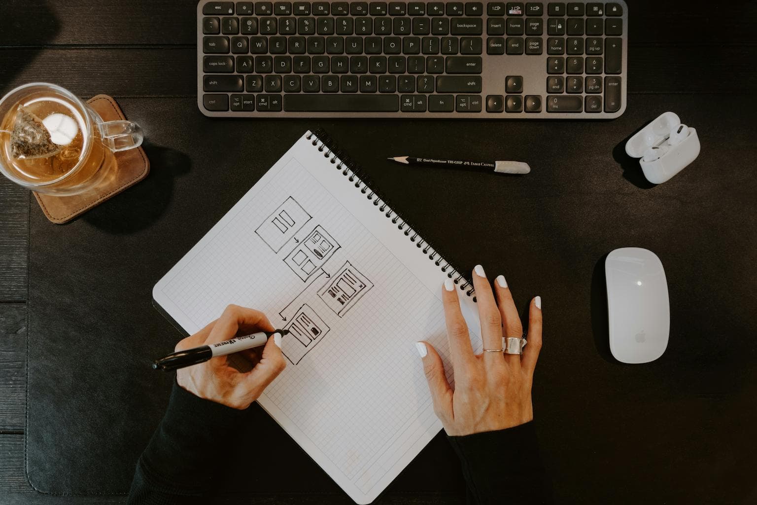 Designer sketching wireframes for a user interface in a notebook